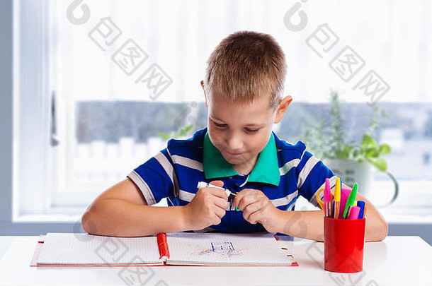 快乐快乐的孩子在<strong>画册</strong>中用画笔画画，使用了很多绘画工具。创意概念。
