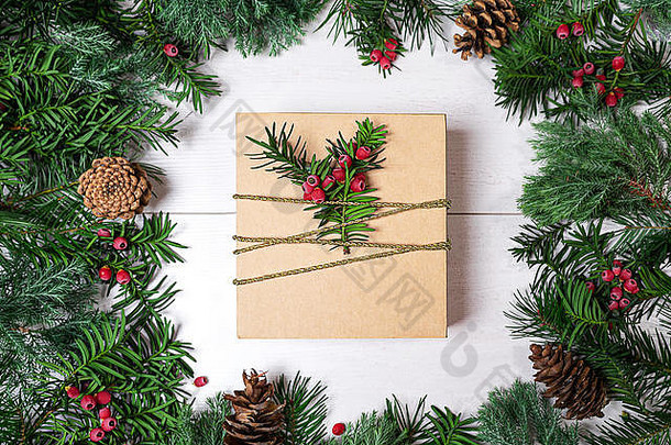 圣诞<strong>礼品</strong>盒和木质<strong>背景</strong>上带有<strong>红色</strong>浆果的冷杉树枝。寒假作文。平面布置，俯视新年布局。文本的空间。假期布局的框架。