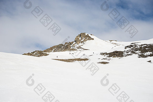 登山者们在雪坡上<strong>滑雪</strong>上山，朝山顶走去。战胜逆境和到达的概念