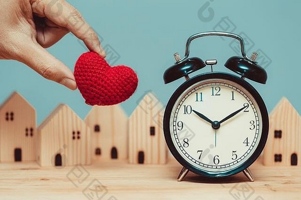 爱的心与时间时钟木制家居背景的时间留在家里的概念。