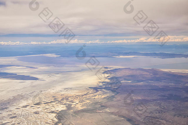 从飞机上鸟瞰落基山山脉的大盐湖，在春天的白天，云层和风景<strong>一览</strong>无余。在犹他州，美国