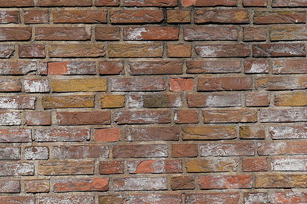 旧红砖墙显示出老化和砂浆腐烂的迹象。