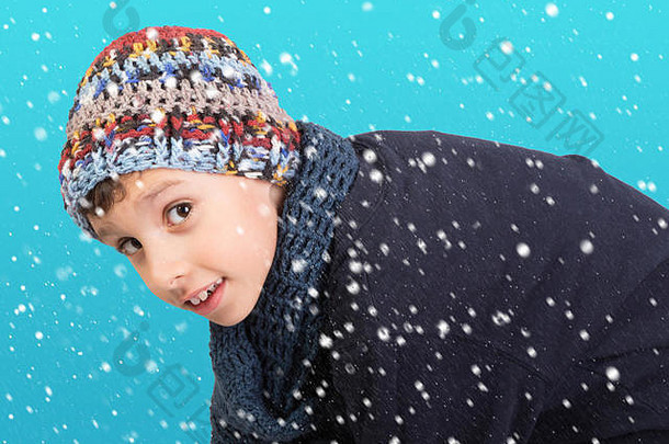 冬天-可爱的小男孩，戴着温暖的帽子，背景是蓝色的雪花