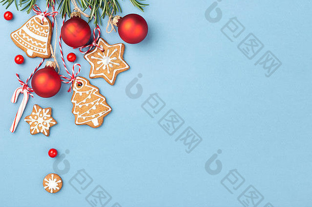 姜饼饼干红色的圣诞节球糖果狗棒棒糖挂蓝色的背景装饰浆果迷迭香前视图复制空间
