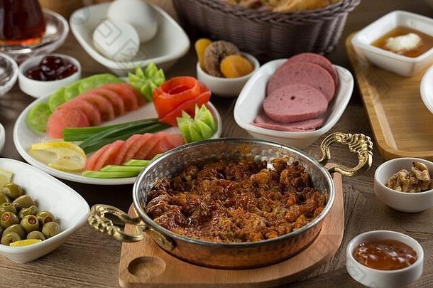 传统土耳其早餐配芝麻百吉饼和香肠煎蛋。用过的陶瓷早餐<strong>套装</strong>和铜蛋<strong>盘</strong>。