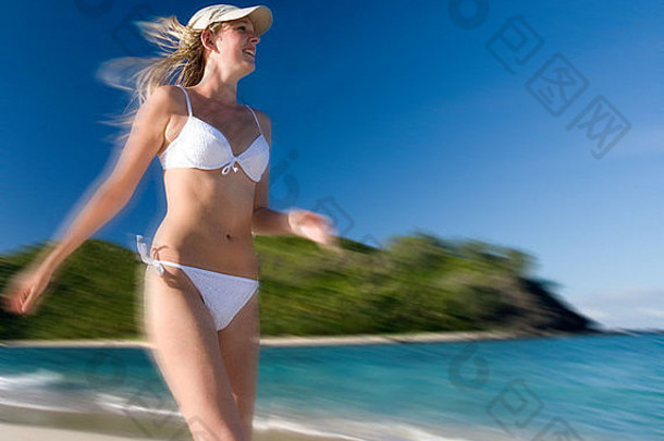 穿着比基尼在南太平洋斐济的热带海滩上跑步的女孩