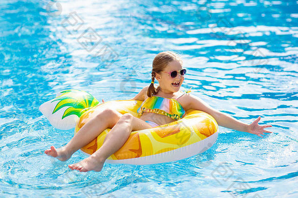 带着充气<strong>菠萝</strong>玩具环的孩子漂浮在游泳池里。在热带度假胜地的室外游泳池里学习游泳和跳水的小女孩。游泳