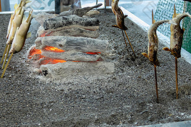 <strong>烧烤</strong>岩华鱼或山形鱼，在木棍上的煤块旁<strong>烧烤</strong>，这是日本日兴公司Kegon falls的一种著名食物。