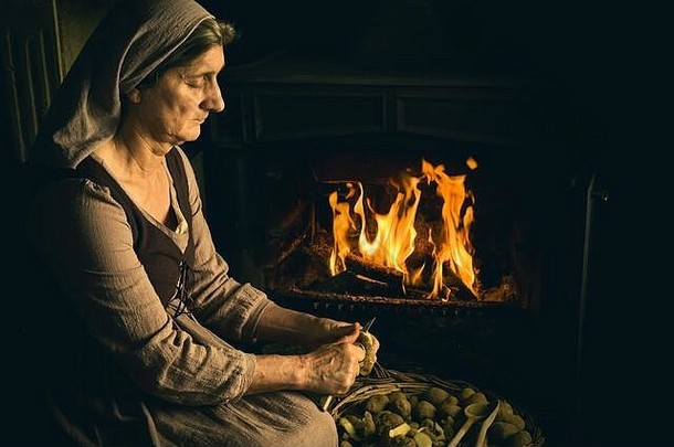 文艺复兴时期的老大师画，一位农妇在壁炉前削土豆