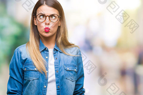 年轻漂亮的女人戴着眼镜在孤立的背景下用嘴唇<strong>做鱼</strong>脸，疯狂而滑稽的姿势。滑稽的表情。