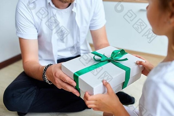 小女孩在父亲节那天给她英俊的父亲一个礼物盒