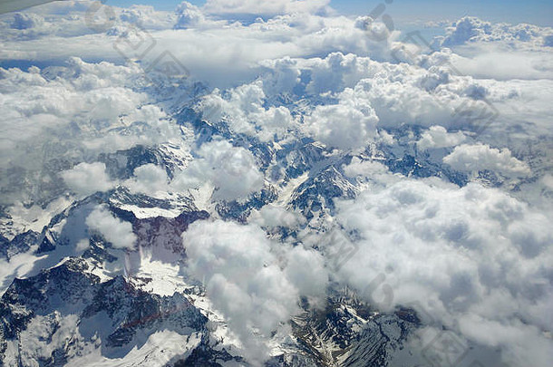从空中俯瞰云层和覆盖着白雪的阿尔卑斯山