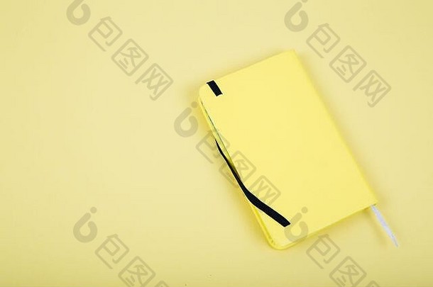 黄色背景上的黄色皮革笔记本。商业概念