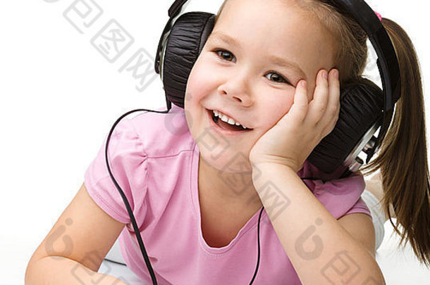 可爱的小女孩用耳机欣赏音乐，隔着白色