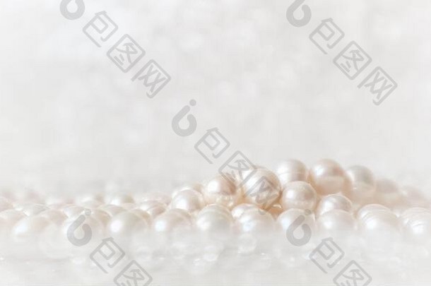 自然的白色珍珠串在闪闪发光的背景上，柔和聚焦，具有高光