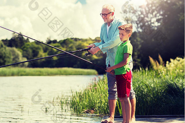 爷爷和孙子在河边的泊位上钓鱼