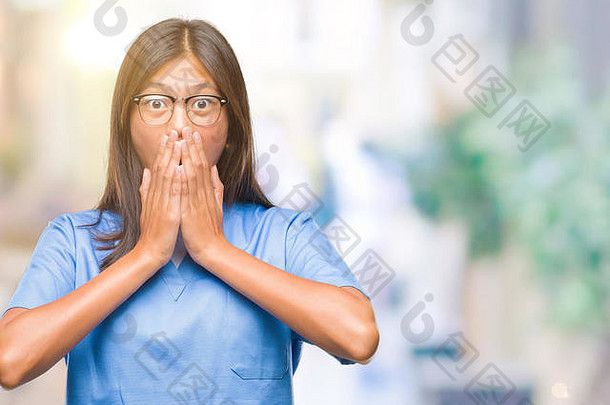 一名年轻的亚洲女医生在隔离的背景下震惊地用手捂住嘴，因为她犯了错误。秘密概念。