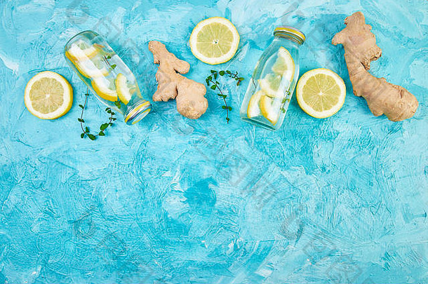 时尚排毒健康饮料。在瓶子里放一些成分，姜，柠檬，薄荷，蓝色的背景。<strong>夏日</strong>饮料，<strong>柠檬水</strong>。饮食平铺。T