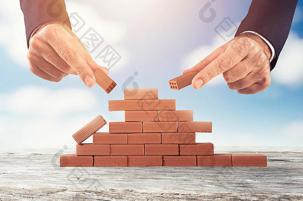 商人用砖砌墙。新业务、合作、整合和创业的概念