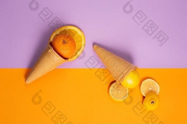 带有天然橙子和柠檬水果的冰淇淋。真正和生物水果的概念。紫色和黄色背景