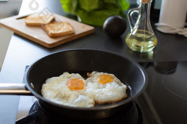 在家庭厨房的<strong>现代感</strong>应炉上准备清晨鸡蛋早餐。
