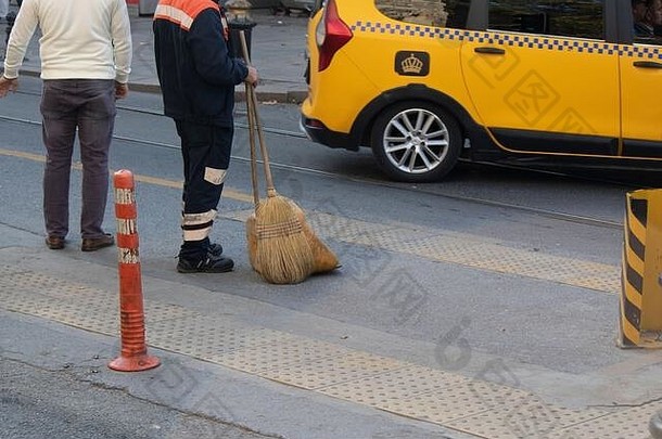 城市工人清洁路边沥青扫帚铲手