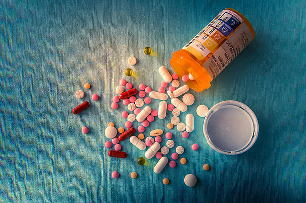 平板电脑药片胶囊堆混合治疗药物抗抑郁药抗生素止痛药蓝色的白色背景