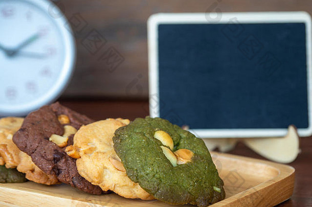 多色饼干，包括花生酱、绿茶饼干和巧克力片饼干。在木板上用交替的颜色覆盖。白氯
