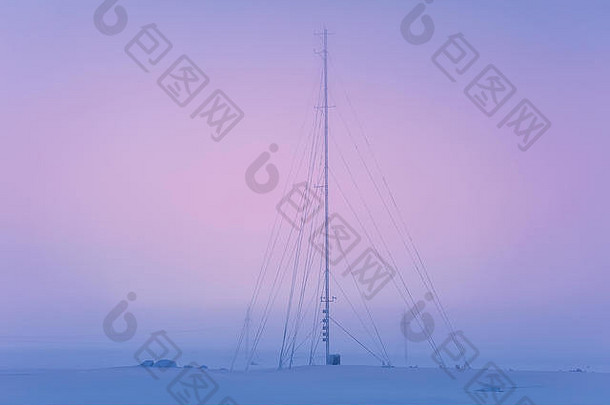 日落时冻结的无线电天线。雪雾和极端天气。摩尔曼斯克区。科拉半岛。俄罗斯极地地区。