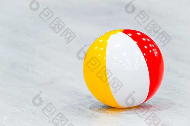 橡胶海滩黄色的白色红色的球躺灰色的木地板上