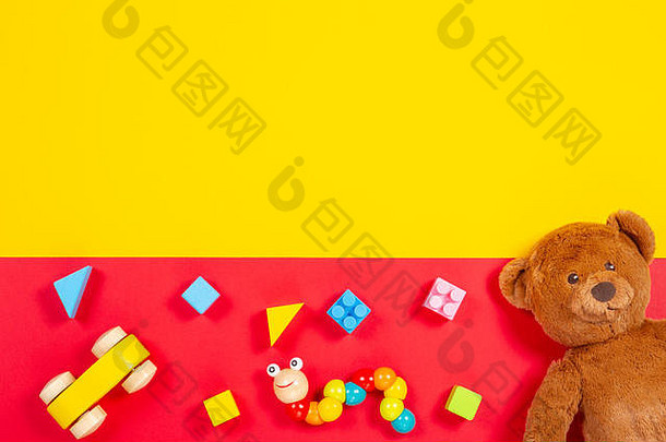 婴儿玩具背景。泰迪熊，木车，红色和黄色背景上的彩色砖块