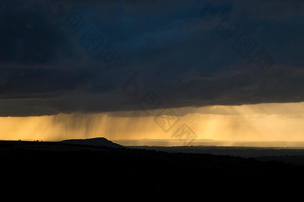 日落时分，英国柴郡乡村上空乌云密布。从斯塔福德郡的蟑螂看。