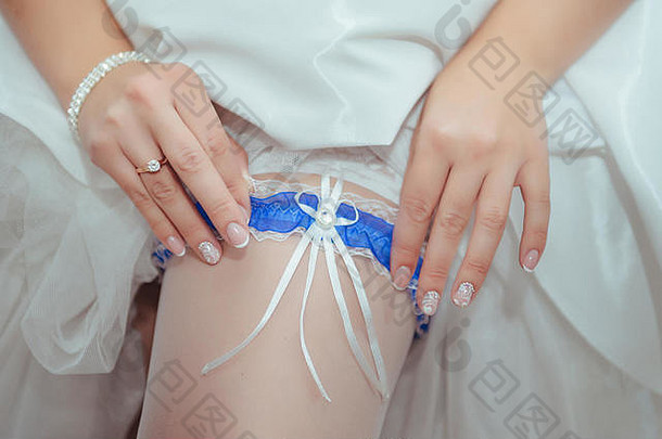 新娘把婚礼吊袜带戴在腿上