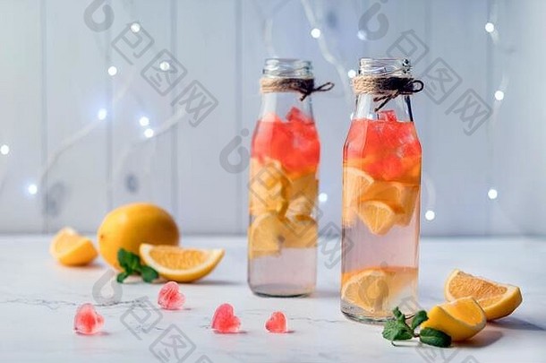 大理石桌上放着提神柠檬水和心形冰块的瓶子。用柑<strong>橘</strong>类水果浸泡的可口的水。<strong>情人节</strong>饮料。美味的
