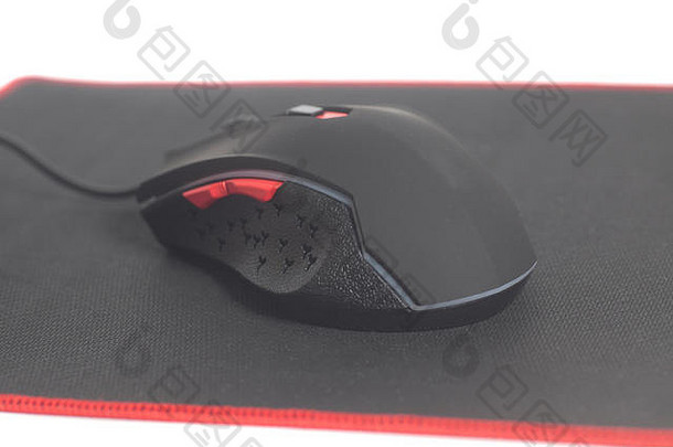 电脑现代游戏鼠标在白色背景上隔离的黑色鼠标垫上