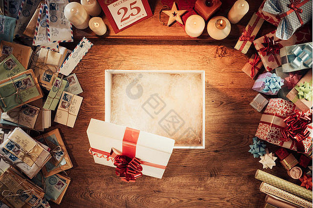 打开木制桌面上的空<strong>圣诞</strong>礼品<strong>盒</strong>，四周是信件和礼物，俯视图