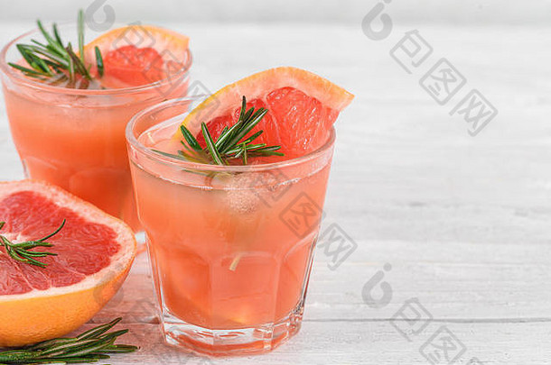 葡萄柚鸡尾<strong>酒</strong>，配迷迭香和冰块，白底。健康的柑橘夏季饮料。闭合
