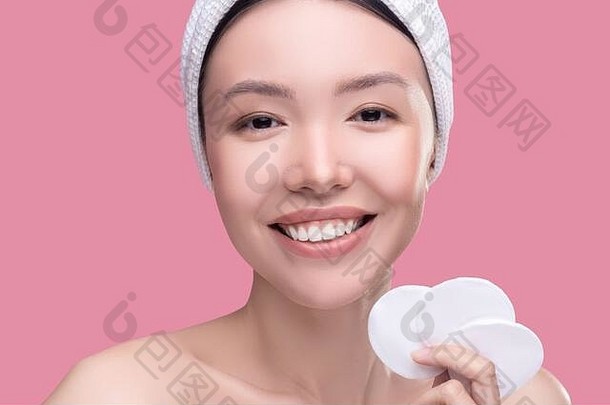 微笑亚洲女孩白色头巾持有海绵清洁