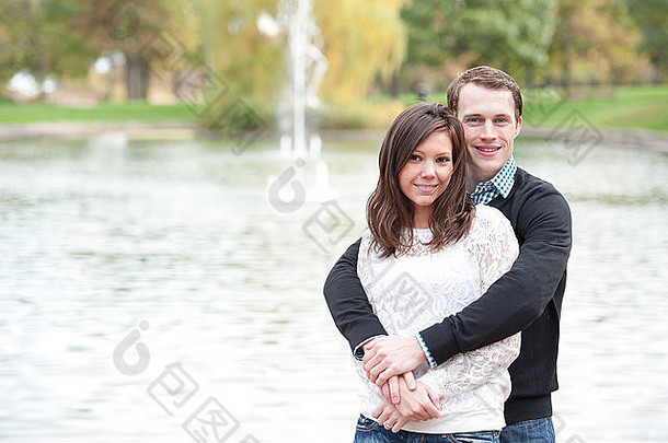 有吸引力的年轻的夫妇摆姿势池塘阳光明媚的一天