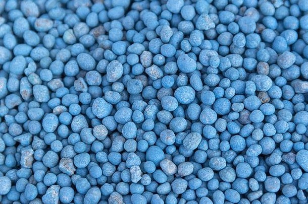 蓝色不同形状的化肥颗粒作为抽象背景。