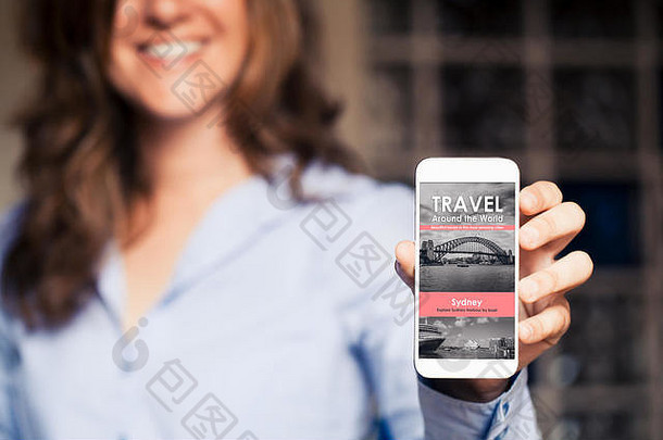 一位面带微笑的女士手持手机，屏幕上显示着旅游新闻网站。