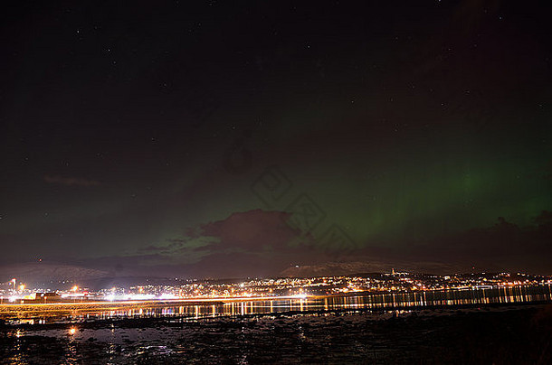 深秋北极城市特罗姆索上空强烈的北极光