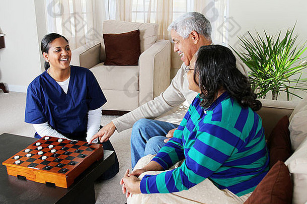 家庭保健员和一对老年夫妇在玩游戏