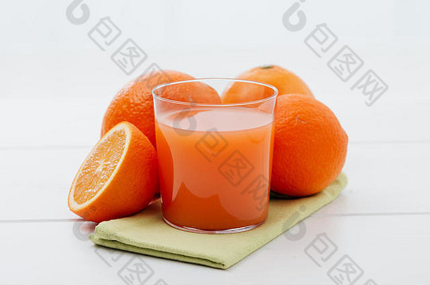 厨房餐桌上的健康美味果汁和新鲜橙子：健康食品和饮料概念