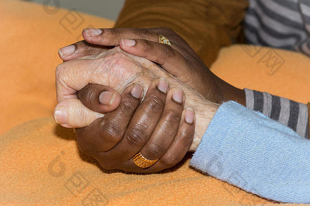 护士牵着一位年长妇女的手。帮手理念，关爱老人。
