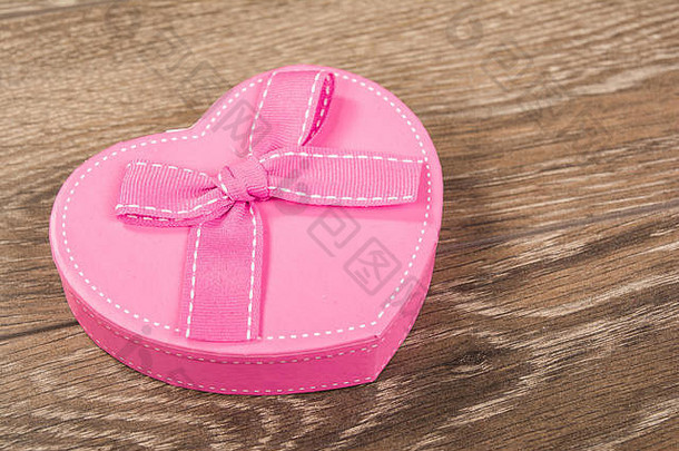 木制背景上有粉红色缎带的粉红色礼品盒