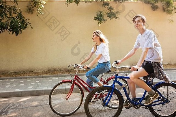 很<strong>酷</strong>的<strong>男孩</strong>幸福的相机骑自行车漂亮的女孩年轻的夫妇支出时间骑红色的蓝色的