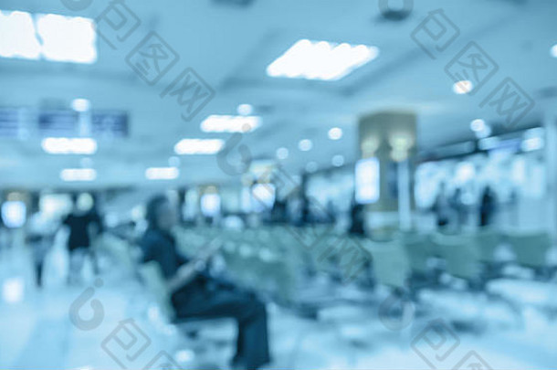 医院背景的抽象照片模糊，病人坐在椅子上等待医生。