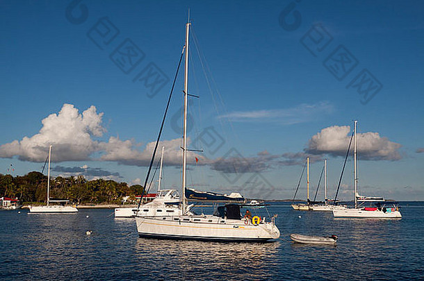 下午，在英属维尔京群岛托托拉岛的玛丽娜礁，帆船停泊在深蓝色的海水中