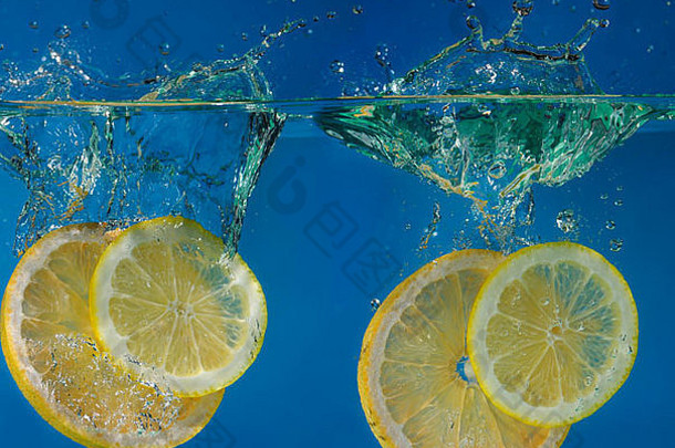 双柠檬<strong>葡萄柚</strong>片溅水蓝色的背景